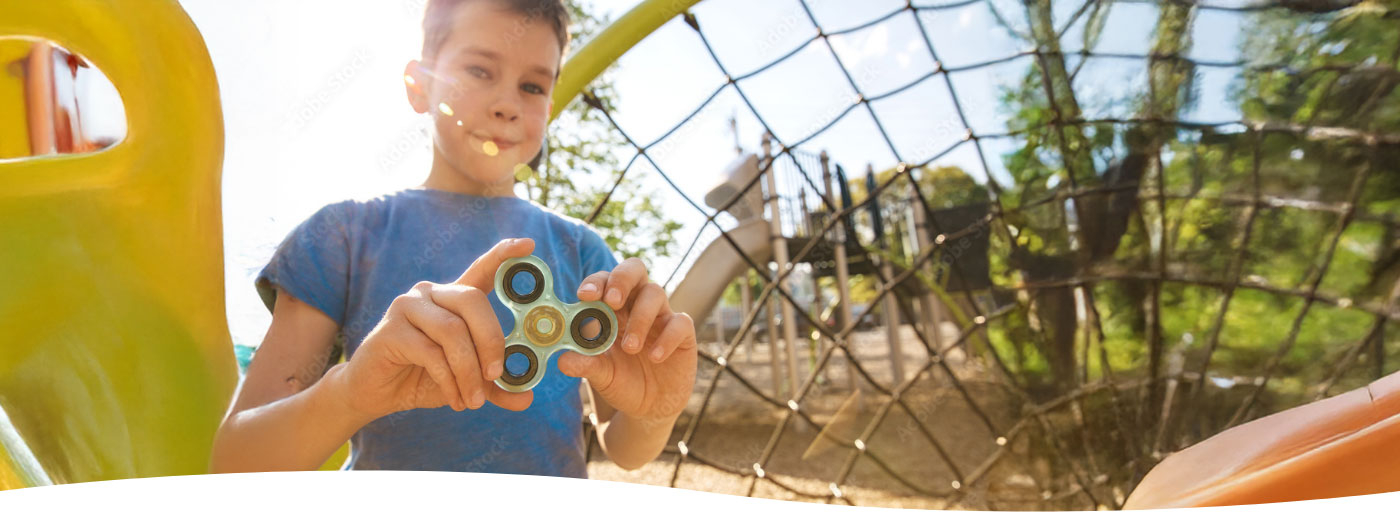 Spielender Bub auf einem Spielplatz vor einer Rutsche